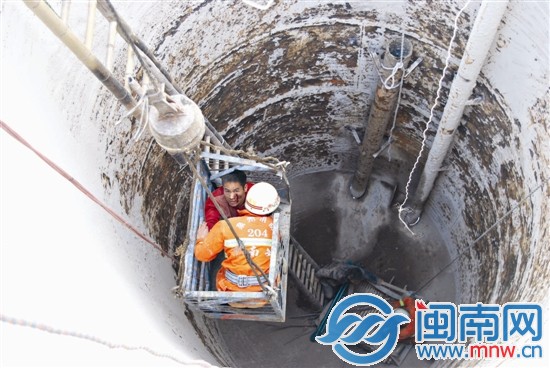 吊機(jī)將受傷工人和消防隊(duì)員吊出污水處理罐