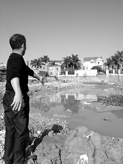 村民指著“被拓寬”的池塘。