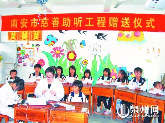 工作人員為失聰兒童安裝助聽器