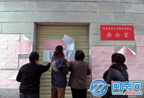 漢唐天下小區(qū)業(yè)主翻看新貼出來的公告