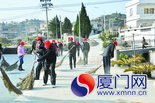 一群特殊的志愿者在軍營(yíng)村的馬路上開(kāi)展衛(wèi)生清潔工作。