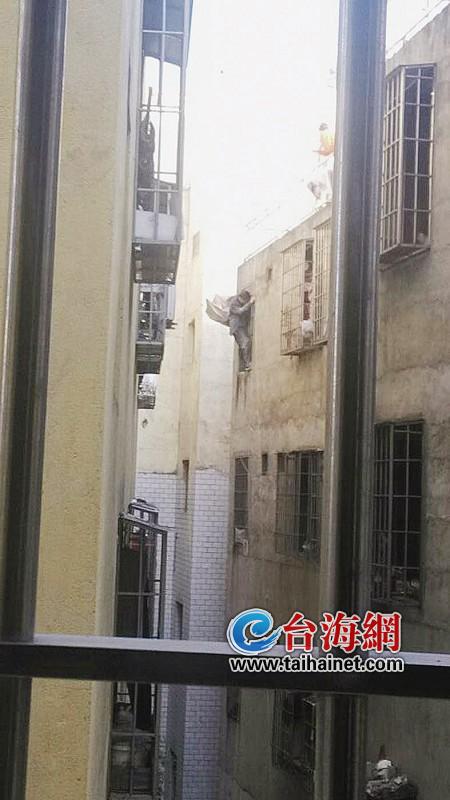 男子攀爬在5樓窗戶的護(hù)欄上
