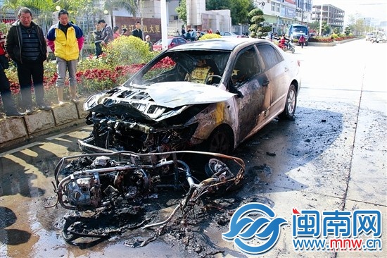 火被撲滅后,小車前躺著一輛被燒得只剩鋼架的助力車