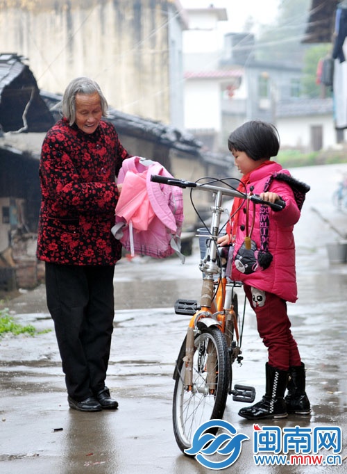小彩蓮冒著雨騎車回家