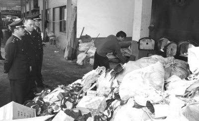 工人正往焚燒爐內(nèi)投放假冒商品