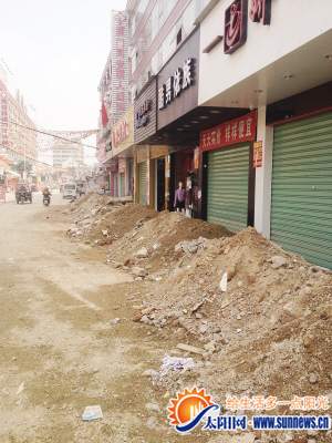 店門前堆著小山丘似的渣土