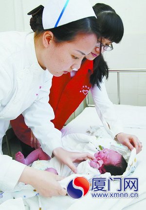醫(yī)院志愿者和護(hù)士為寶寶更換尿布
