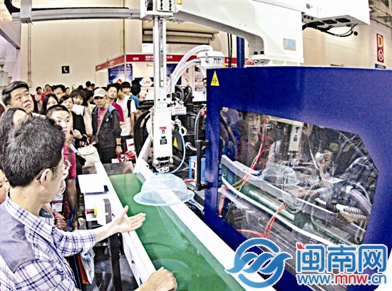 在臺(tái)交會(huì)展館，注塑機(jī)現(xiàn)場(chǎng)生產(chǎn)塑料盆，吸引很多市民