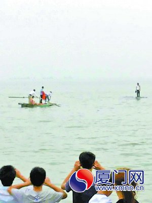 眾人劃船，靠近礁石救援被困人員。