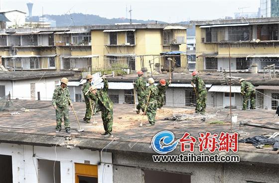 工人揮起大錘敲向屋頂