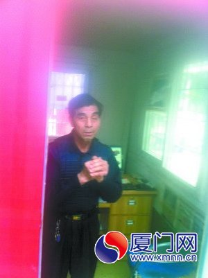 劉明高演示在保安亭內(nèi)作揖的動(dòng)作