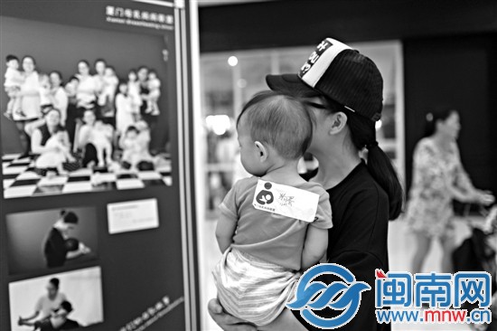 一位媽媽在觀看哺乳攝影展圖片