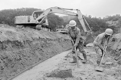施工人員利用雨歇的間隙忙著架設(shè)模板