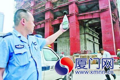 執(zhí)法人員檢測工地噪聲。