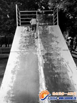 滑梯上寫“專業(yè)板場，閑人勿進(jìn)”，但有小朋友在玩耍