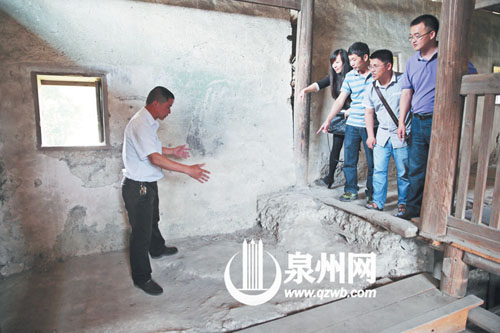 許進(jìn)丁向游客們比劃著土樓墻體的厚度，當(dāng)年建造土樓