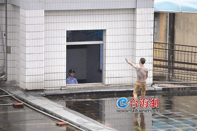 男子持雙刀爬上樓頂，警方正在勸說1