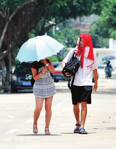 連日的暴雨突然銷聲匿跡，酷日悄悄降臨。一位撐傘的