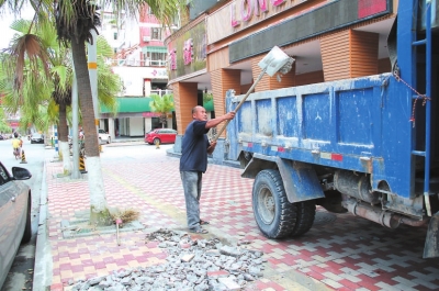 在市區(qū)長安街，工人正在清理路面修補(bǔ)后遺留下來的垃