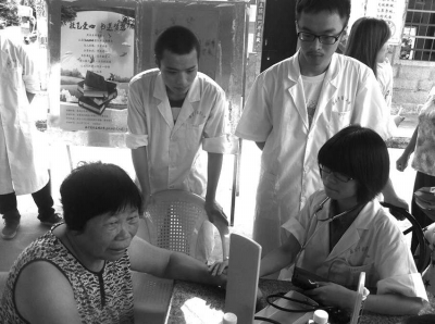 社會(huì)實(shí)踐活動(dòng)小組成員為黃碧蓮阿婆量血壓。