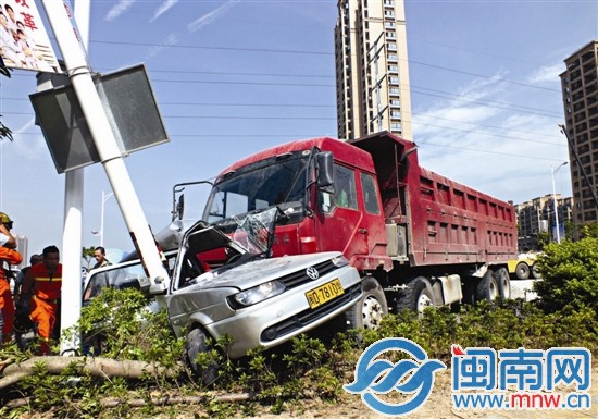 轎車被路燈桿與土方車死死卡住