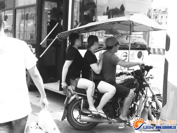 載客摩托車穿梭在公交車縫隙間