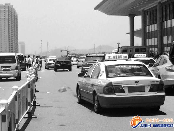 在出站口，不少的士排隊(duì)拉客。