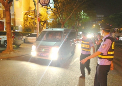 交警攔下濫開遠(yuǎn)光燈車輛。本報(bào)記者朱晨輝攝