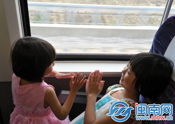 動(dòng)車(chē)上，朱心琴姐妹玩拍手游戲打發(fā)時(shí)間