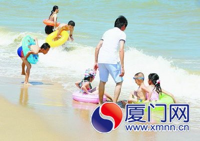 昨日，市民在環(huán)島路海邊戲浪消暑