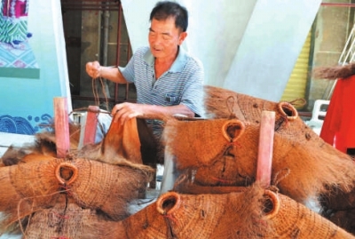 蓑衣制作傳承人詩山鎮(zhèn)鵬峰村的陳奕培在現(xiàn)場(chǎng)制作蓑衣。