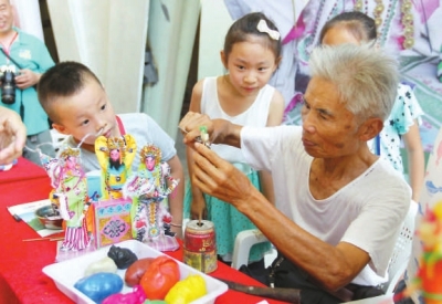 肖其昌在傳授小朋友妝糕人制作技藝。