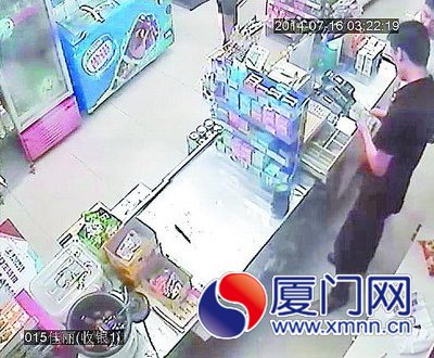 　一名男子從收銀機(jī)里拿錢