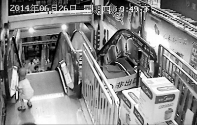 監(jiān)控顯示，白衣“熊孩子”按下電梯的緊急停止按鈕。